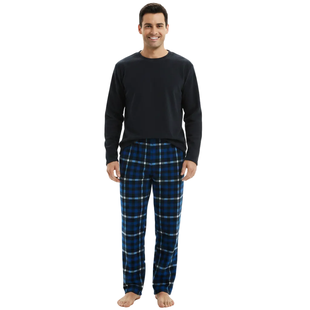 A man modeling a two-piece pajama set consisting of a solid black long-sleeve crewneck shirt and blue plaid pajama pants with white and black lines, shot against a solid white background.