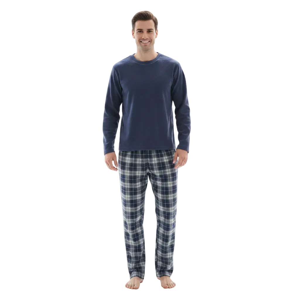 A man modeling a navy blue long-sleeve crewneck shirt and matching navy and gray plaid pajama pants against a plain white background.