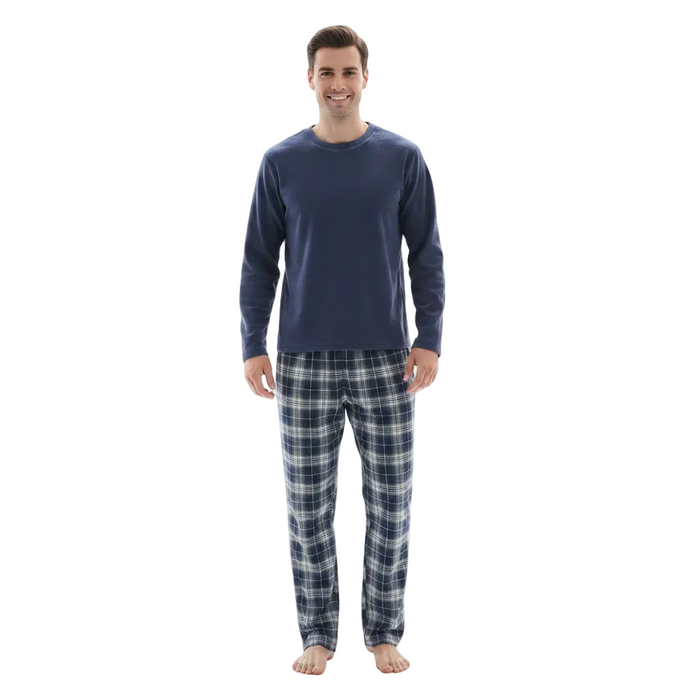 A man modeling a navy blue long-sleeve crewneck shirt and matching navy and gray plaid pajama pants against a plain white background.