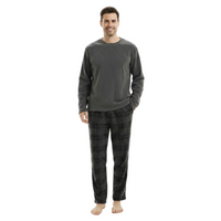 A man modeling a dark gray long-sleeve crewneck shirt and dark gray/black plaid pajama pants against a solid white background.