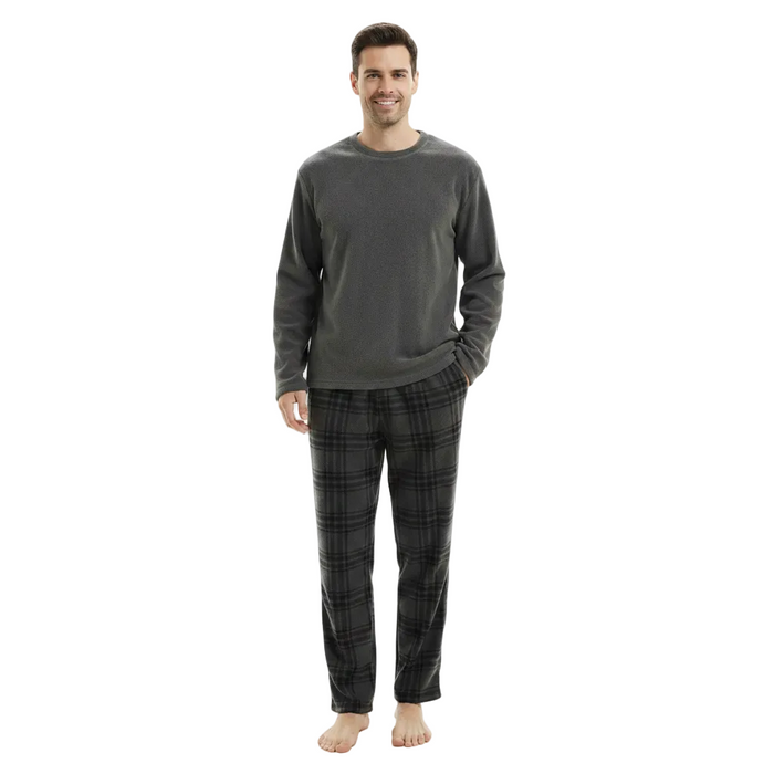 A man modeling a dark gray long-sleeve crewneck shirt and dark gray/black plaid pajama pants against a solid white background.