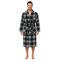 A man wearing a black and white plaid bathrobe, standing against a plain white background.