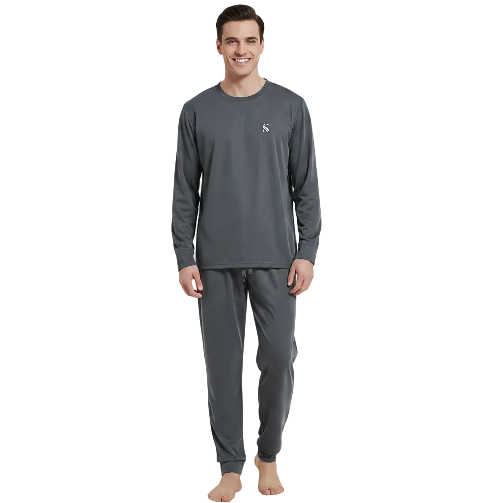 A man modeling a dark gray long-sleeve crewneck shirt and matching dark gray jogger pants against a plain white background.