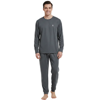 A man modeling a dark gray long-sleeve crewneck shirt and matching dark gray jogger pants against a plain white background.