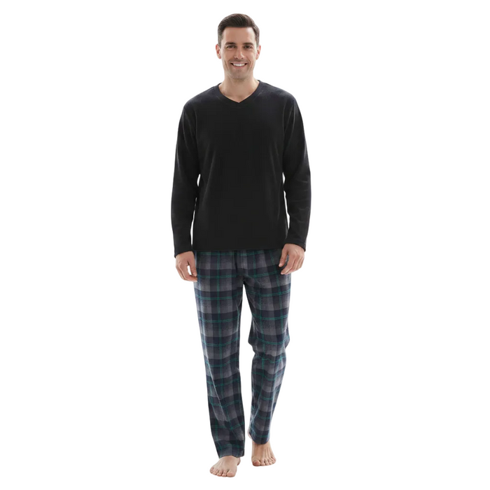 A man modeling a men's pajama set consisting of a black long-sleeve V-neck shirt and dark blue plaid pajama pants, standing against a solid white background.