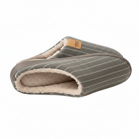 A pair of slip-on slippers with a gray pinstripe exterior, a soft beige sherpa lining, and a small tan brand patch on the side.