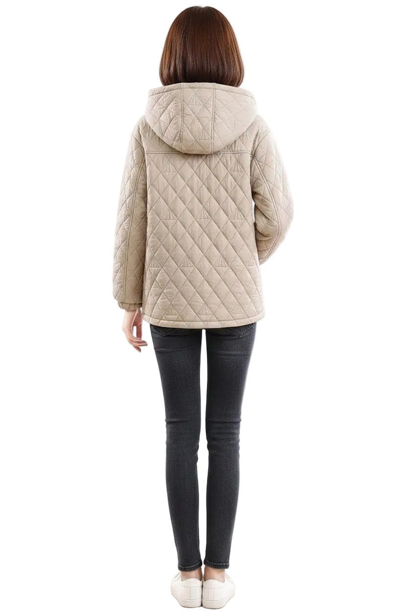 A woman viewed from the back wearing a light beige quilted hooded jacket, black skinny jeans, and white sneakers against a plain white background.