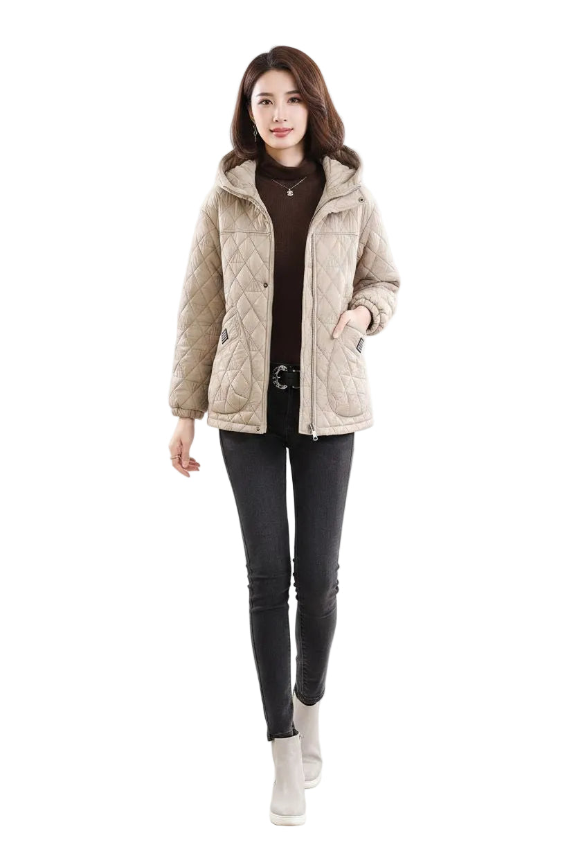 A woman modeling a light beige quilted puffer jacket over a dark brown turtleneck, black skinny pants, and light gray ankle boots, set against a plain white studio background.