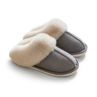 A pair of slip-on slippers with a smooth gray suede-like upper and thick cream faux-fur trim around the opening, shown on a clean white background.