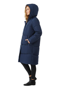 A woman wearing a long navy blue hooded puffer coat, styled with black leggings and black ankle boots, shown in profile against a solid white background.