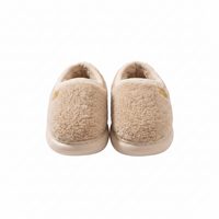 A pair of beige sherpa fleece slip-on slippers shown from the back on a plain white background.