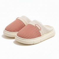 A pair of slip-on slippers with a dusty pink knit upper and cream ribbed trim and sole, shown on a clean white background.
