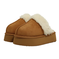 A pair of women's slip-on clogs in warm camel brown suede with thick platform soles and fluffy cream shearling lining, shown on a clean white background.