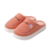 A pair of ribbed knit slip-on slippers in a dusty coral pink color, featuring black embroidered 'LUPY LIFE' text and a small purple cartoon bunny logo on the side, with white soles.
