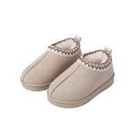 A pair of beige slip-on winter slippers with a soft white faux-fur lining and a decorative brown zigzag stitched trim around the collar, shown on a clean white background.