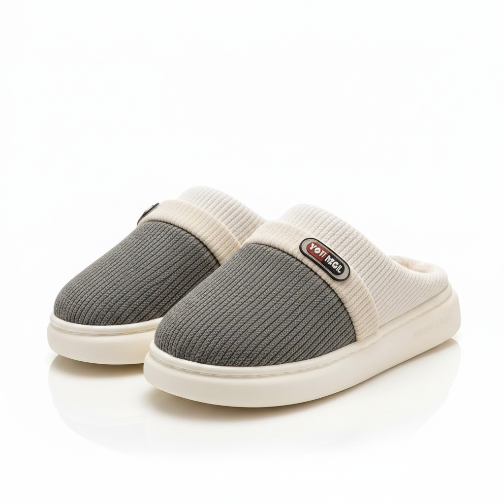 A pair of slip-on mule slippers with a textured gray upper and cream ribbed trim and sole, shown on a clean white background.