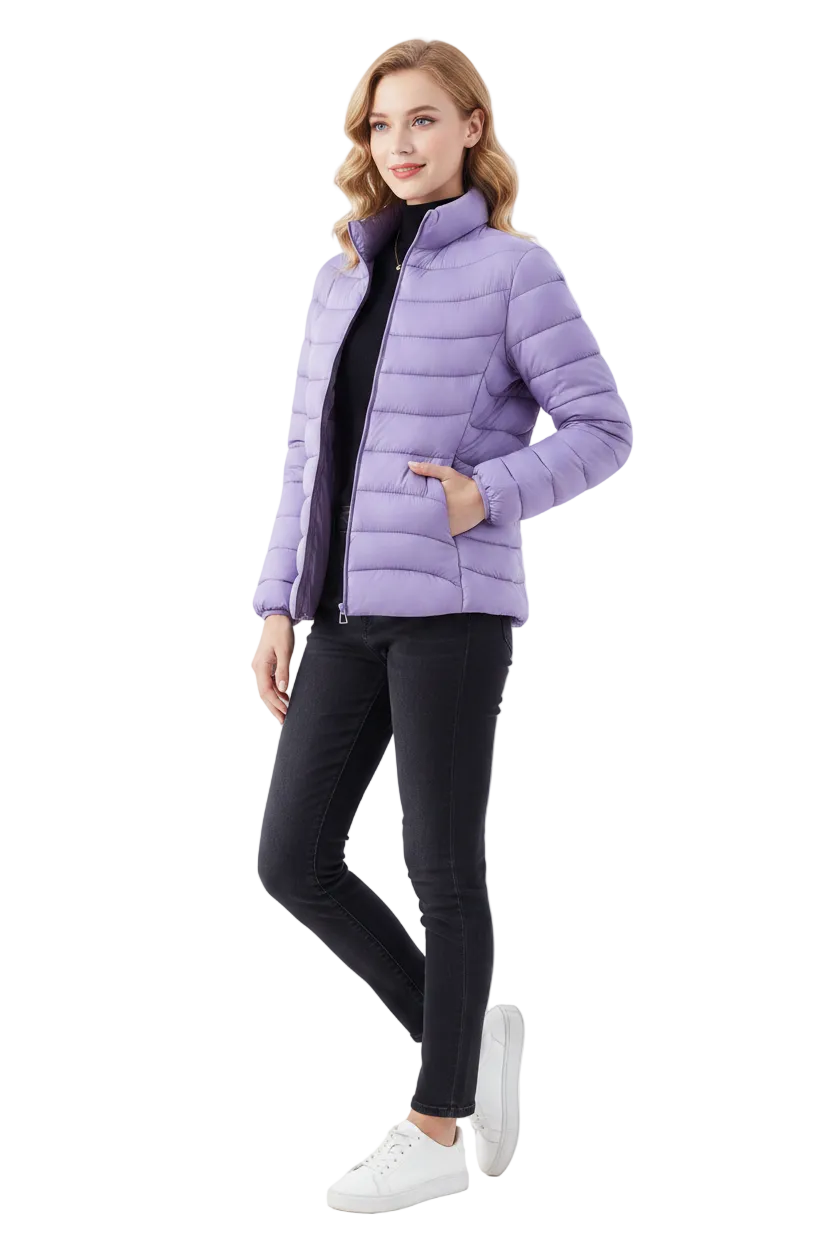 A woman modeling a light purple puffer jacket over a black top and black skinny jeans, paired with white sneakers, against a plain white studio background.