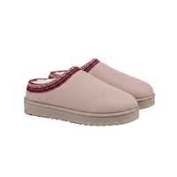 A pair of slip-on clogs in a dusty pink fabric, featuring a red and white patterned trim around the collar and a thick beige platform sole.