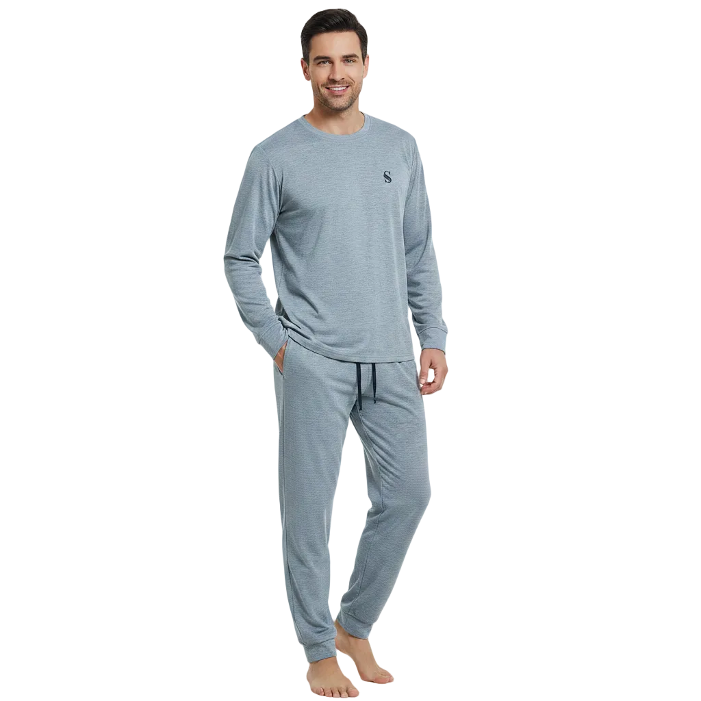 A man modeling a light blue-gray long-sleeve crewneck shirt and matching jogger pants with a drawstring, shown against a plain white background.