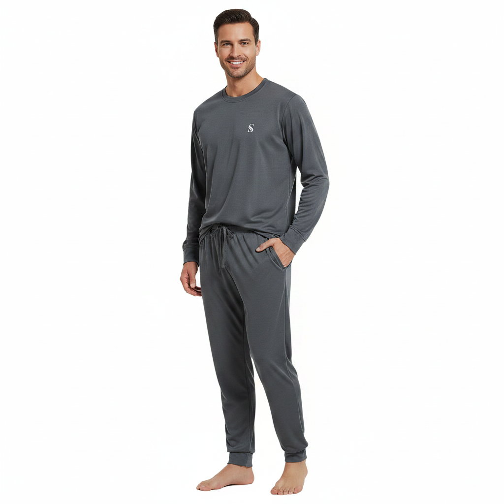 A man modeling a dark gray long-sleeve crewneck shirt and matching jogger pants with a drawstring waist and side pockets, shown against a plain white background.