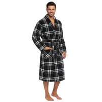 A man modeling a plush black and white plaid bathrobe against a solid white background.