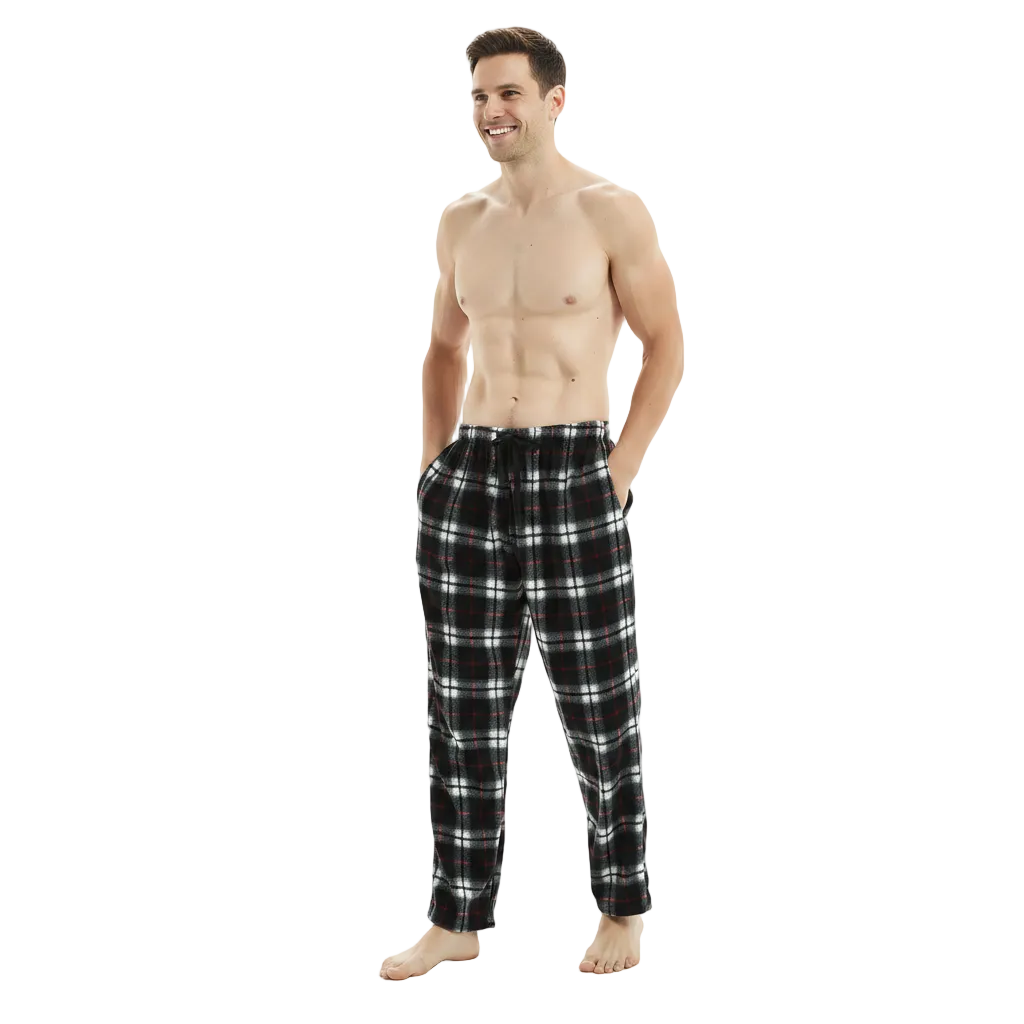 A shirtless man wearing black, white, and red plaid pajama pants, standing against a plain white studio background.