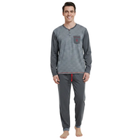 A man modeling a two-piece long-sleeve pajama set consisting of a gray and white striped henley shirt with a chest pocket and matching gray jogger pants with a red drawstring, shot against a solid white background.