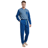 A man modeling a two-piece pajama set consisting of a long-sleeve henley shirt with a blue and white striped body and solid blue sleeves, paired with matching blue drawstring pants, against a plain white background.