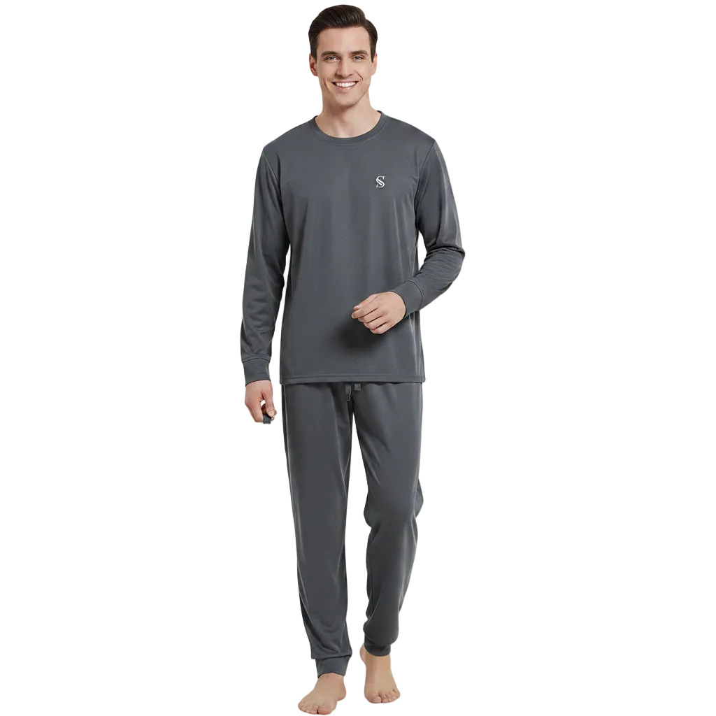 A man modeling a dark gray long-sleeve pajama set with matching jogger pants and a small white embroidered logo on the chest, standing against a plain white background.