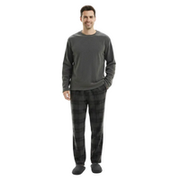 A man modeling a dark gray long-sleeve crewneck shirt and matching dark gray plaid pajama pants with black slippers, shot against a solid white background.