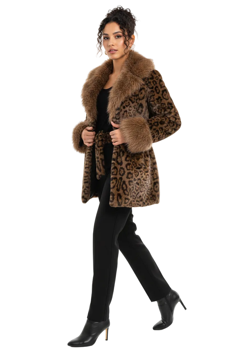 A woman modeling a leopard-print faux fur coat with a large brown fur collar, worn over a black outfit and black ankle boots, against a solid white background.