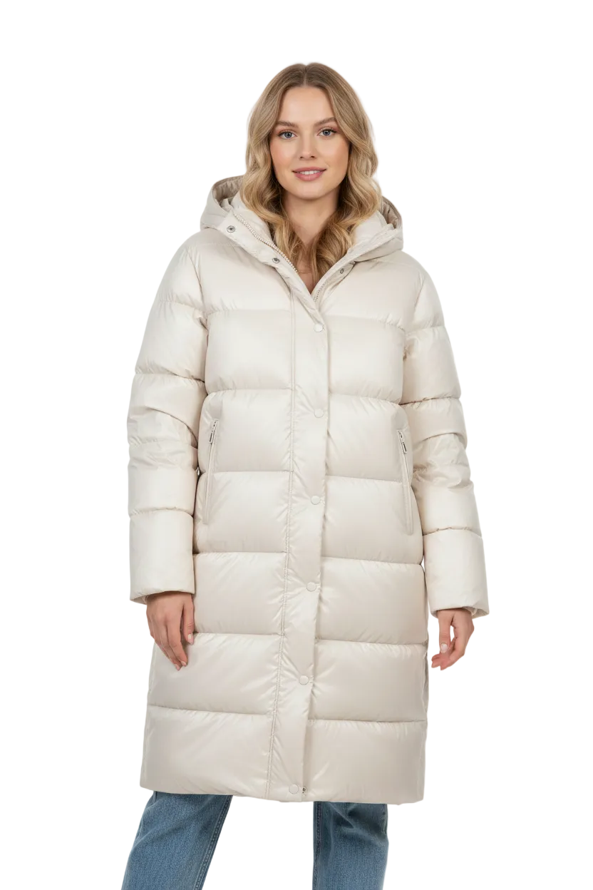 A woman wearing a long, hooded puffer coat in a light cream or off-white color, paired with blue jeans, photographed against a seamless white studio background.