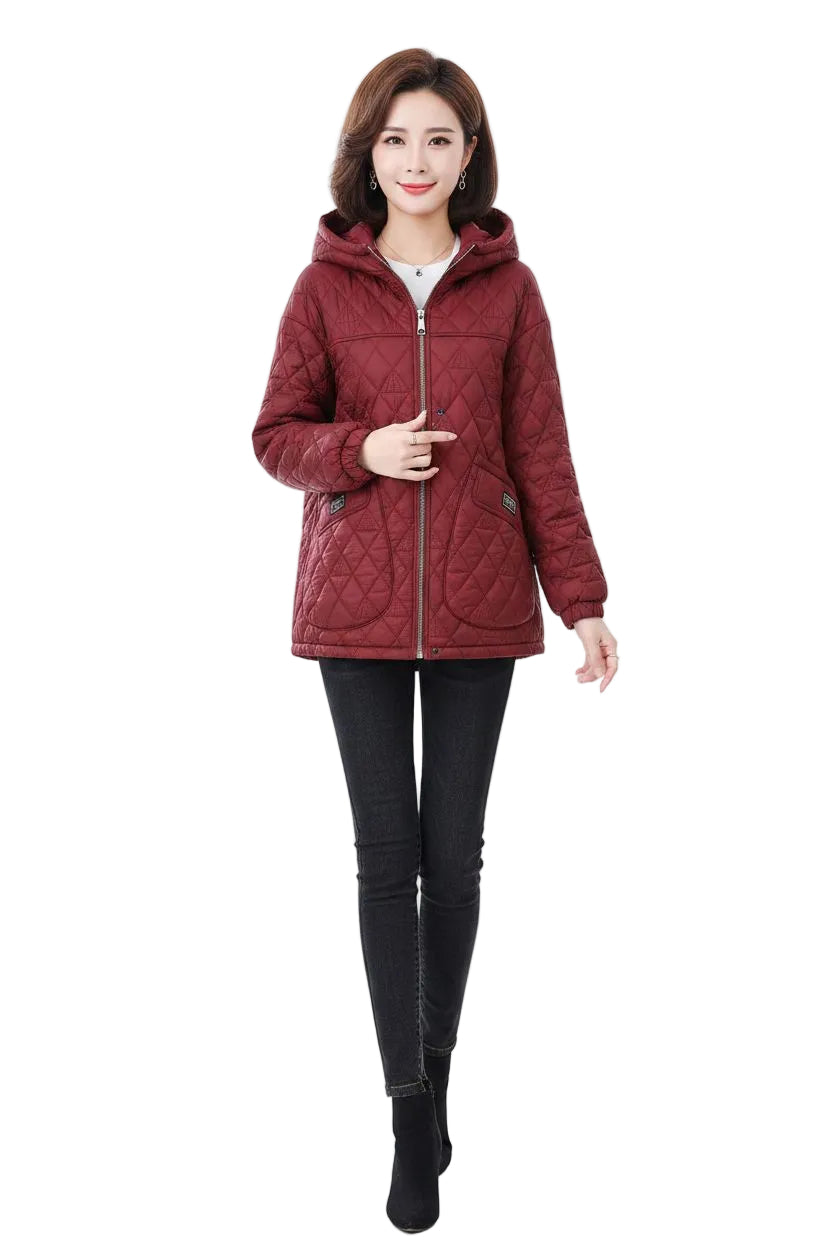 A woman modeling a quilted, cropped hooded jacket in a deep burgundy red. The jacket features a diamond-quilted pattern, a front zipper, and a hood.