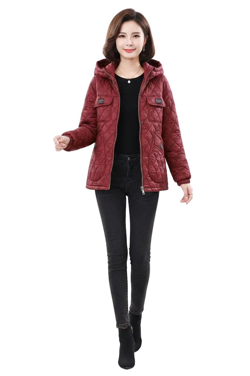A woman modeling a quilted hooded jacket in a deep burgundy red color, styled with a black top and black skinny pants against a plain white background.