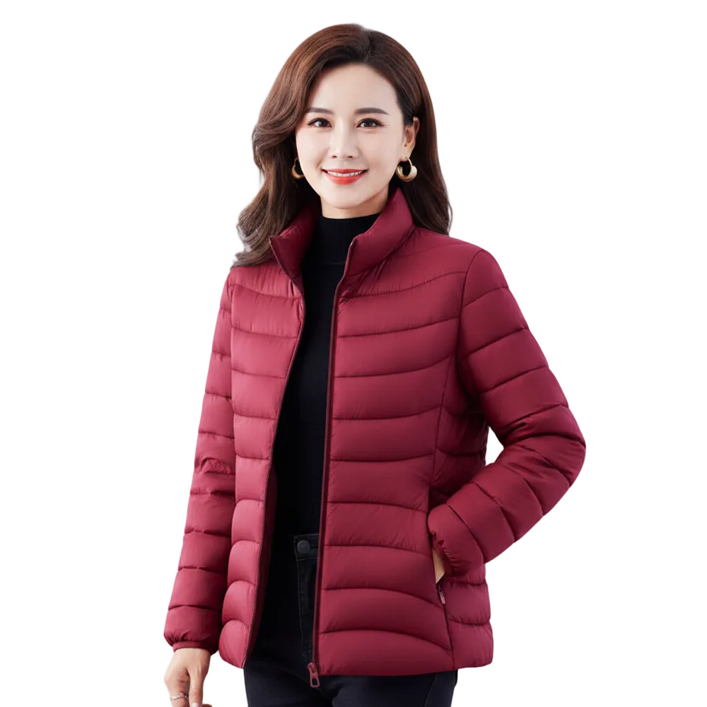 A woman wearing a short, quilted puffer jacket in a deep burgundy red over a black top, photographed against a solid white background.
